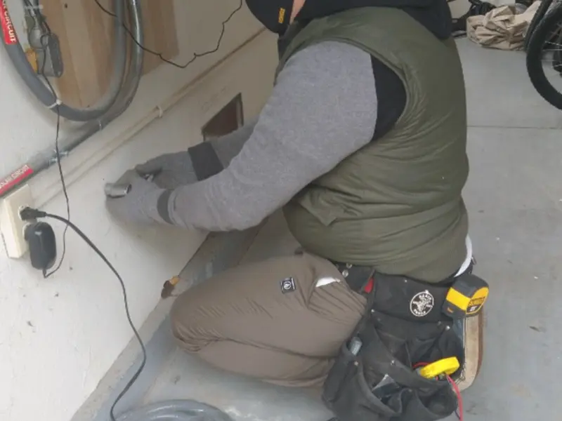 Electrician performing outlet wiring in a Cortez garage